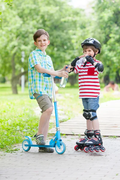 Dois meninos com scooter e rolos — Fotografia de Stock