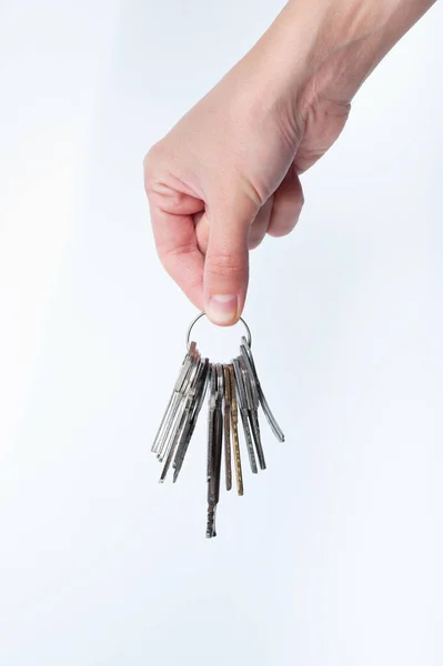 Hand houdt een bos van sleutels uit het appartement geïsoleerd op witte achtergrond kopieerruimte — Stockfoto