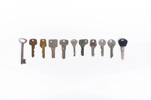 Raccolta di diverse chiavi di casa isolate su sfondo bianco Fotografia Stock