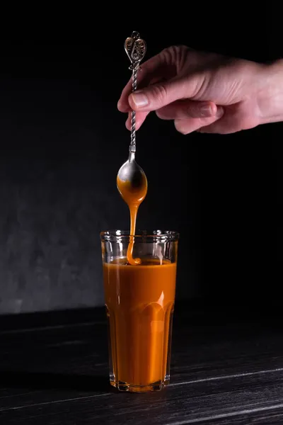 Homemade salted caramel sauce in a jar on a dark background. copy space text — Stock Photo, Image