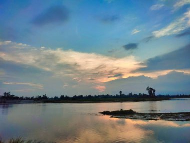 Akşamları bulutlu muhteşem nehir manzarası. Bangladeş 'te günbatımı..