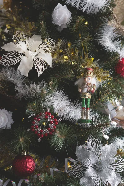 Primer plano de un hermoso árbol de Navidad con bolas blancas de plata y rojo y flores de poinsettia se centran en el cascanueces —  Fotos de Stock