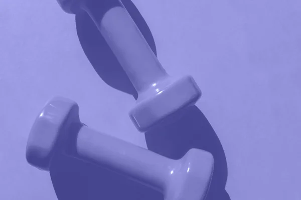 Фіолетові гантелі на фіолетовому фоні — стокове фото