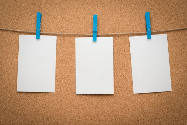 Tres tarjetas de papel memo colgando de una cuerda con cartón de corcho . —  Fotos de Stock