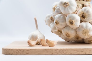 Organik sarımsak bütün ve ahşap kesme tahtası üzerinde karanfil.