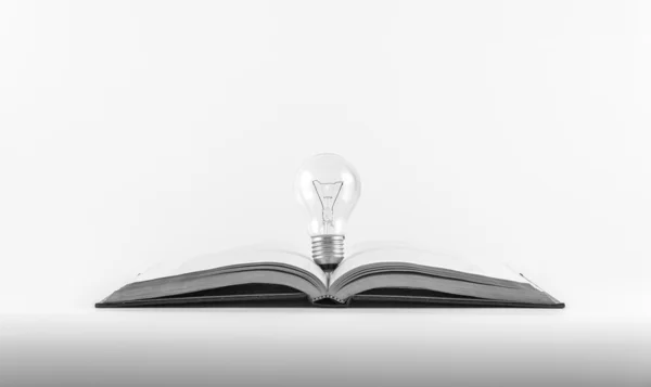 Bombilla de luz en un libro, ajustar blanco y negro, para un concepto de pensamiento . — Foto de Stock