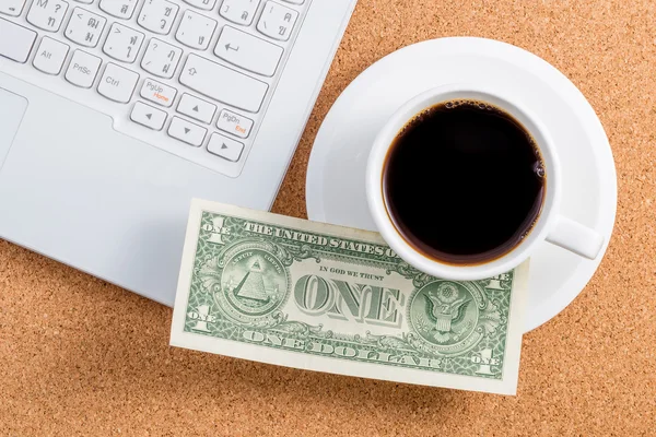 Dollar on a cup of coffee and laptop place — Stock Photo, Image