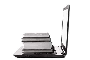 dizüstü bilgisayar üzerinde kitap yığını.