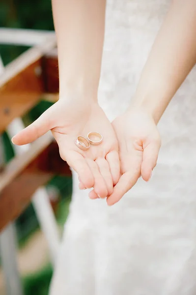 Bride hands holding marriage rings — Stock Photo, Image