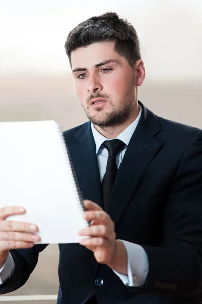 Jeune homme d'affaires regardant le tableau à feuilles mobiles — Photo