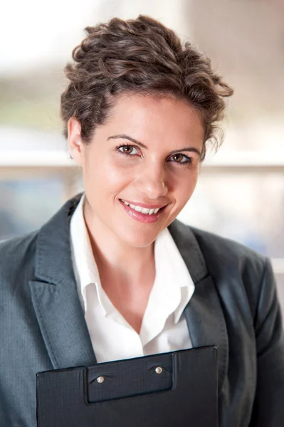 Mujer de negocios sonriendo y sosteniendo un rotafolio —  Fotos de Stock