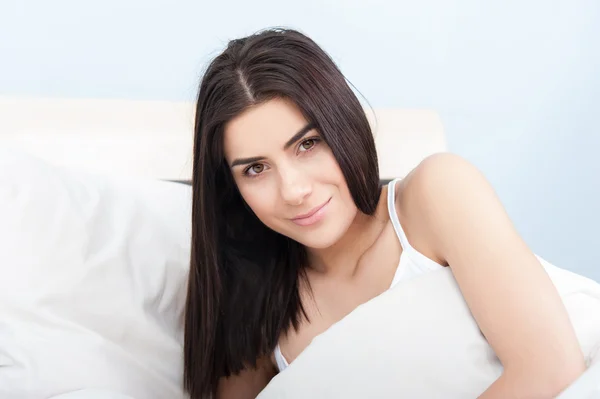 Porträtt av en vacker ung kvinna i sängen tidigt på morgonen — Stockfoto