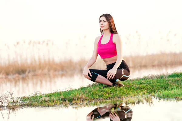 Mujer joven haciendo yoga en la naturaleza — Foto de Stock