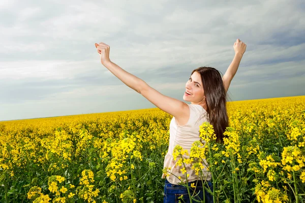 Gelukkig jonge vrouw met handen in de lucht — Stockfoto