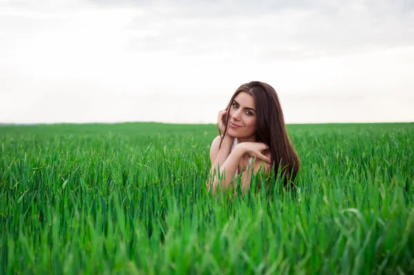 Mladá žena uvolňující a usmívá se v čerstvé zelené louce — Stock fotografie