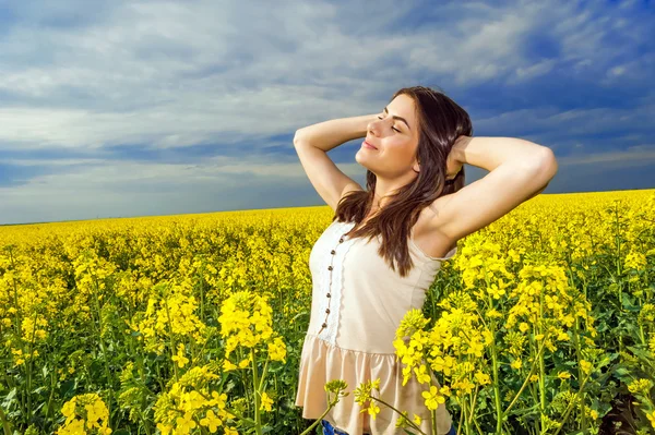 Ritratto di donna rilassante in campo di colore giallo — Foto Stock