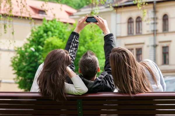 Tres amigos pasando el rato en el parque y tomando fotos de sí mismos — Foto de Stock