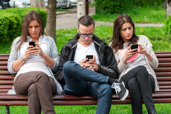 De groep van vrienden kijken op hun telefoons en niet socialiseren met focus — Stockfoto