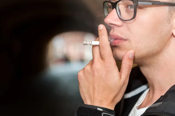 Close up of young man enjoying a smoke