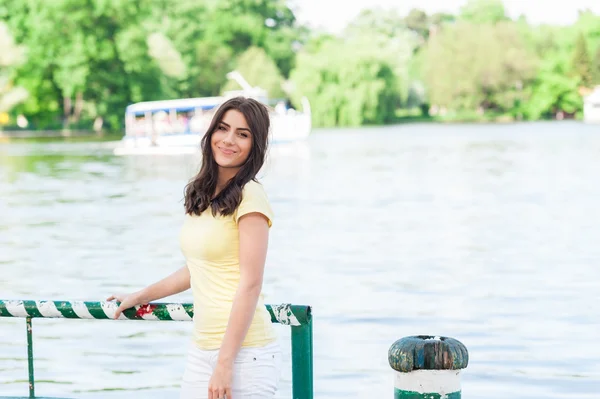 Happy smiling woman sitting in the park by lake — Stock Photo, Image