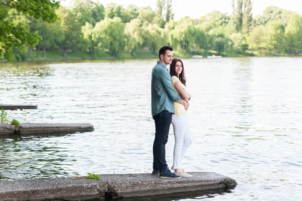自发夫妇爱情，拥抱，在一个石码头. — 图库照片