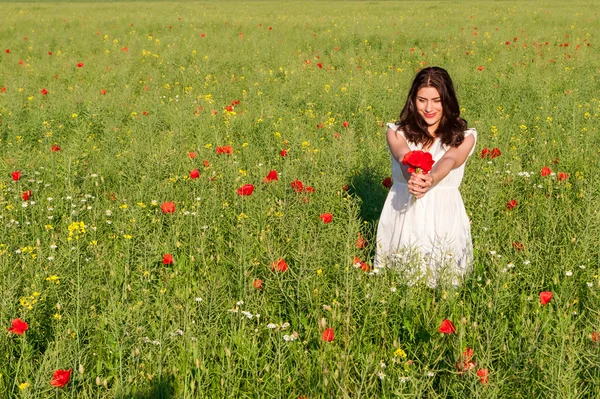Šťastná žena v kvetoucí makové pole venku s kyticí mák — Stock fotografie