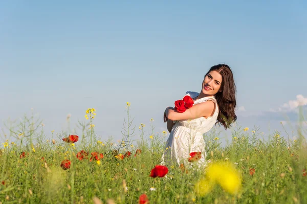 Chica de verano en el campo de amapola sosteniendo un ramo de amapolas —  Fotos de Stock