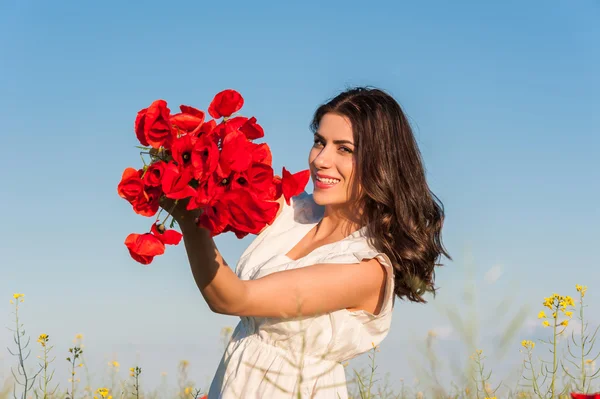 Wanita muda yang bahagia di lapangan dengan buket bunga poppy . — Stok Foto