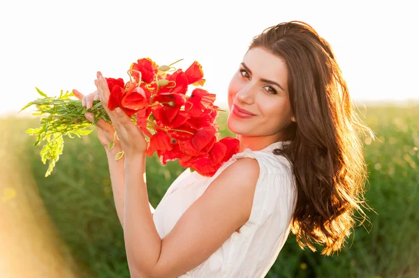 Vrije gelukkig vrouw genieten van natuur in het veld bedrijf een papavers boeket — Stockfoto