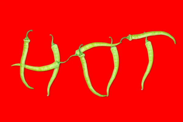HOT texto composto por pimentas. Isolado em fundo vermelho — Fotografia de Stock