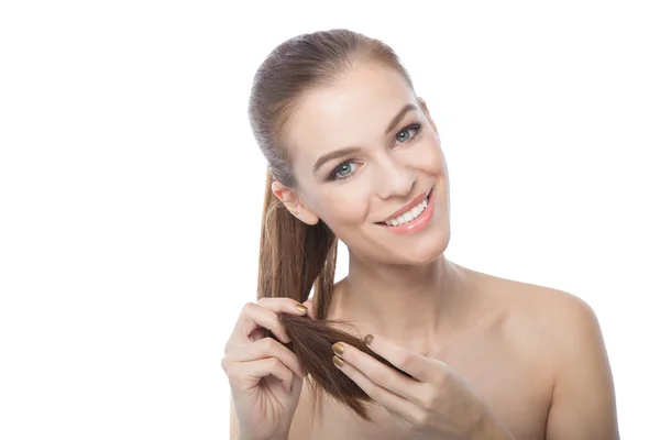 Mulher tocando as extremidades de seu cabelo, no fundo branco — Fotografia de Stock