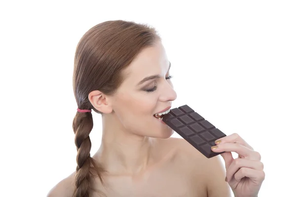 Mujer joven comiendo chocolate. Aislado sobre blanco Imagen de archivo