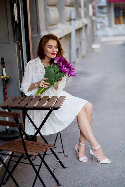 Linda chica en vestido blanco y un hermoso ramo de tulipanes . Fotos De Stock Sin Royalties Gratis