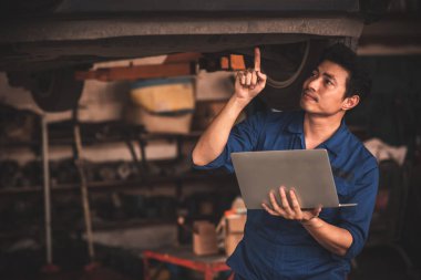 Araba tamirhanesinde çalışan profesyonel bir tamirci..