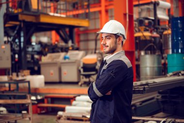 Endüstriyel şantiyede çalışan akıllı fabrika mühendisi, güvenlik şapkası takıyor..
