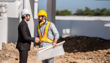 İnşaat işçisi ve mühendis inşaat alanında birlikte çalışıyorlar..