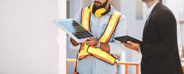 Mühendis Teknisyen ve CEO yöneticileri inşaat halindeki bina için bir güneş paneli inşa etmeyi planlıyorlar. Temiz ve yeşil alternatif enerji kavramı