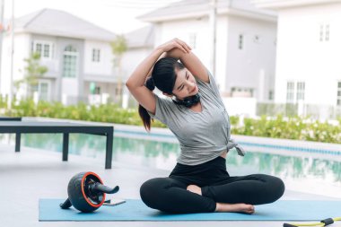 Mutlu Asyalı kadın, sabahları evde egzersiz ve yoga yapıyor. 