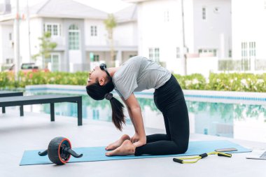 Mutlu Asyalı kadın, sabahları evde egzersiz ve yoga yapıyor. 