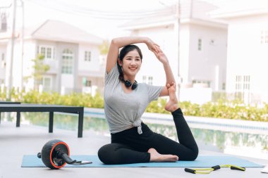 Mutlu Asyalı kadın, sabahları evde egzersiz ve yoga yapıyor. 