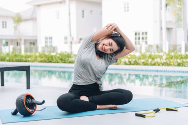 Mutlu Asyalı kadın, sabahları evde egzersiz ve yoga yapıyor. 