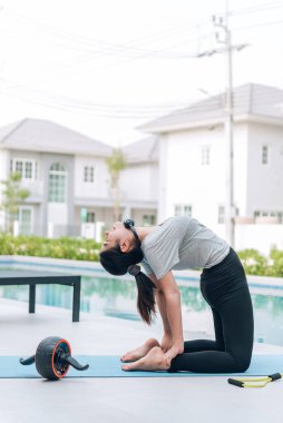 Mutlu Asyalı kadın, sabahları evde egzersiz ve yoga yapıyor. 
