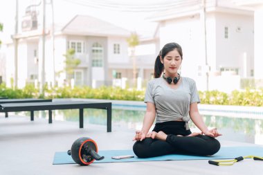 Mutlu Asyalı kadın evde egzersiz yapıyor. 