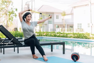 Mutlu Asyalı kadın evde egzersiz yapıyor. 