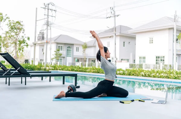 Mutlu Asyalı kadın, sabahları evde egzersiz ve yoga yapıyor. 