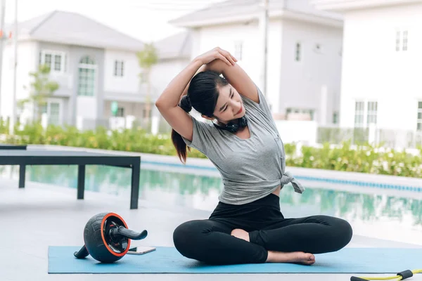 Mutlu Asyalı kadın, sabahları evde egzersiz ve yoga yapıyor. 