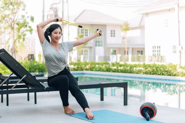 Mutlu Asyalı kadın evde egzersiz yapıyor. 