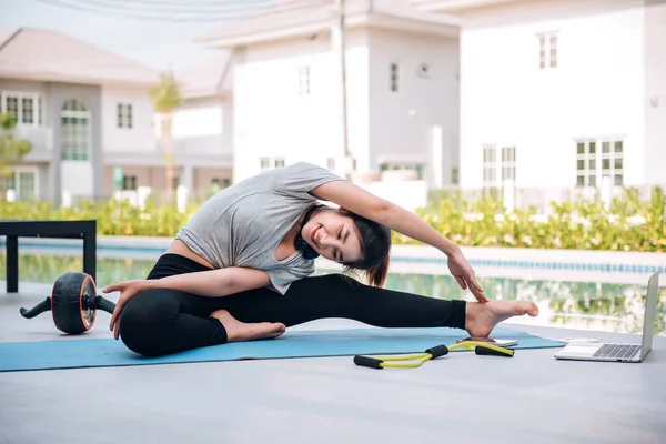 Mutlu Asyalı kadın, sabahları evde egzersiz ve yoga yapıyor. 