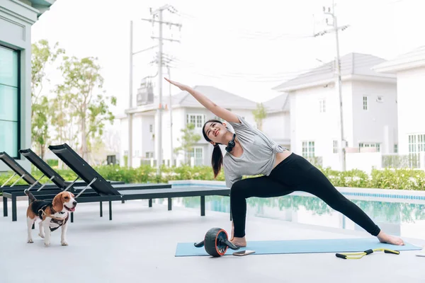 Mutlu Asyalı kadın, sabahları evde egzersiz ve yoga yapıyor.