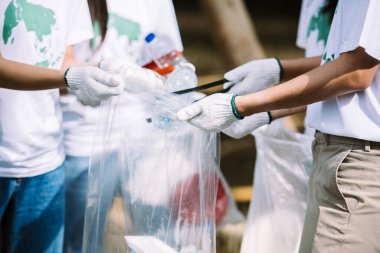 Çeşitli gönüllülerden oluşan bir grup gönüllü takım çalışması, çevre koruma, park alanındaki plastik ve köpük çöplerini toplamak için gönüllü yardım..
